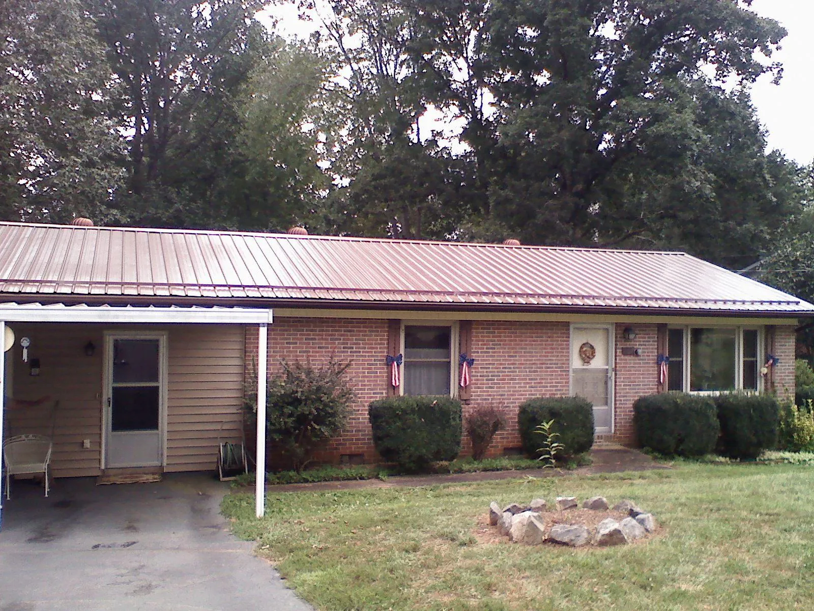 Bronze metal roof and carport on a brick ranch home — Roof Repair work by our crew in Gowrie